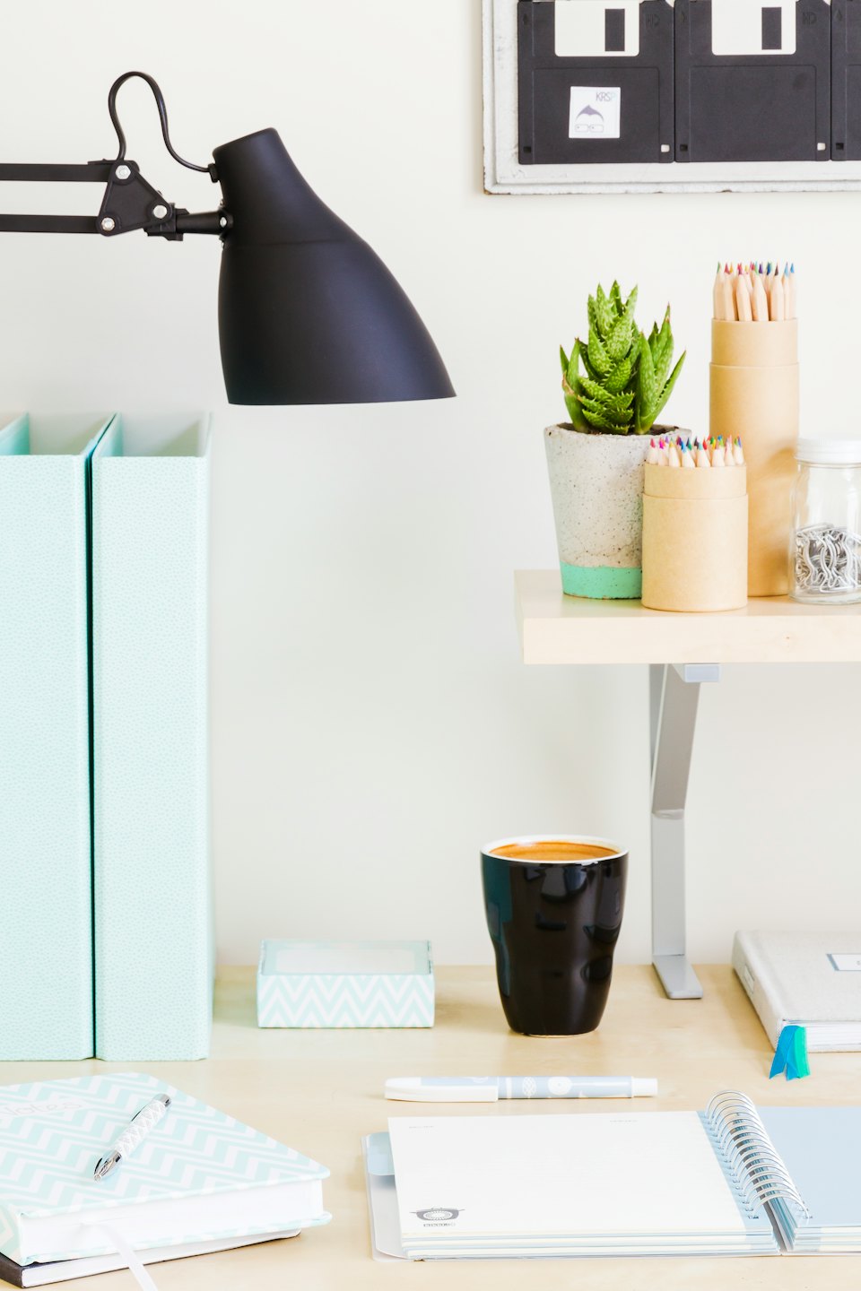 Organized desk with lamp, succulent, and coffee mug.